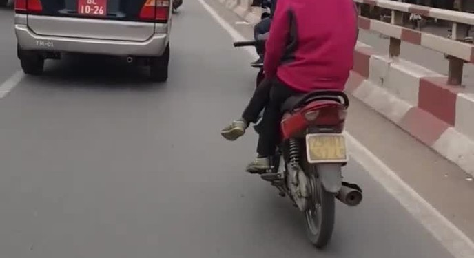 Nín thở cảnh người phụ nữ vắt chéo chân đi xe máy giữa đường, co gối lách giữa 2 ô tô như làm xiếc