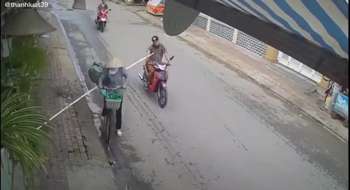 Người phụ nữ dùng ‘gậy Như Ý’ một chạm đẩy ngã người đàn ông đang đi xe máy